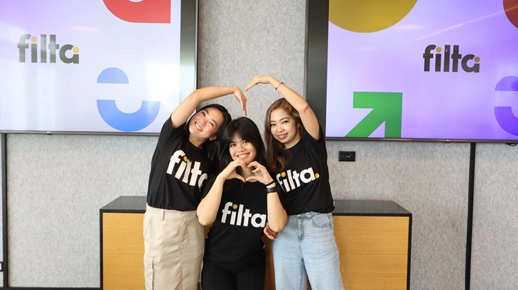 Three Filipino team members forming heart shape with hands in Filta office Manila